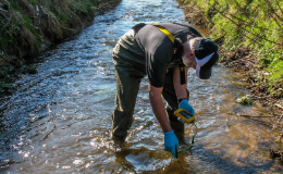 Person in stream measuring in water